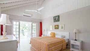 A bedroom with a bed, bedside tables, a ceiling fan, and a window.