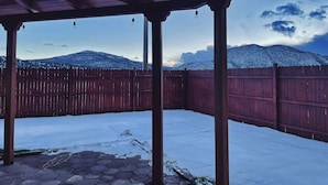 A covered outdoor area with a wooden fence, snow on the ground, and a mountainous backdrop. - Cantina Stagecoach Stop (Grants)