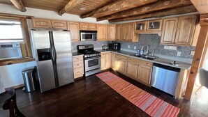 A modern kitchen with wooden cabinets, stainless steel appliances, and a wooden ceiling. - Cantina Stagecoach Stop (Grants)