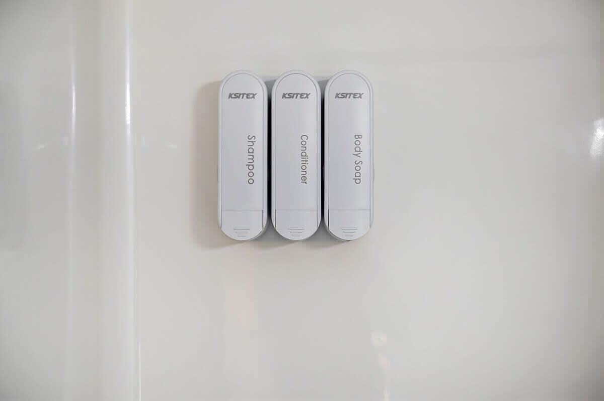 Three white containers labeled 'KSITEX Shampoo,' 'KSITEX Conditioner,' and 'KSITEX Body Soap' on a white surface.