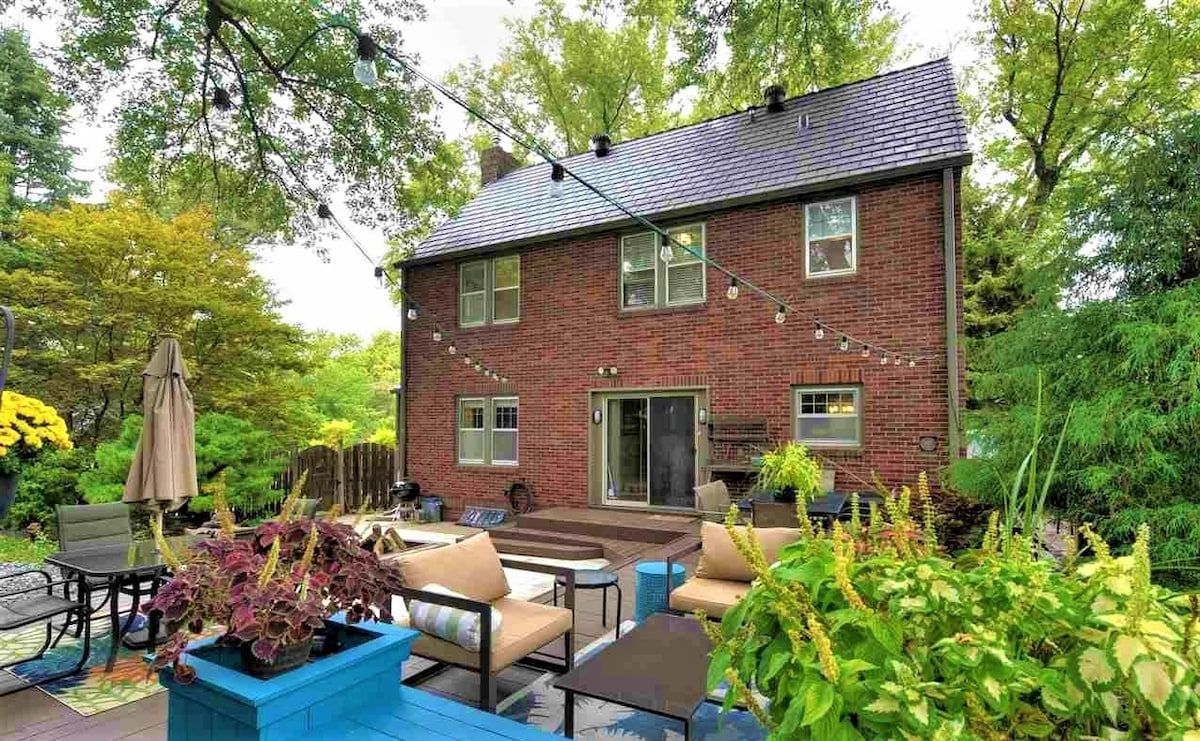 A brick house with a patio area featuring outdoor furniture and potted plants.