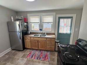 A compact kitchen with a refrigerator, stove, and double sink. - Extended Stay NE Hickory 1 Bedroom 1 Bath Workspace, Washer Dryer, duplex apt. (Hickory)