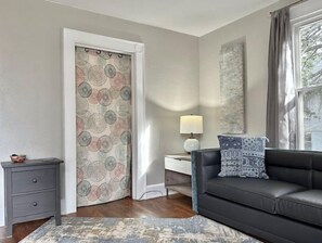 Relax in this inviting living space with a sofa, side table, and lamp, offering a peaceful view of the surrounding trees.