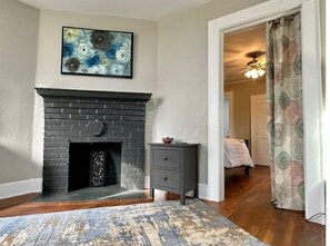 Cozy retreat with a warm fireplace, a side table, and a comfortable seating area.