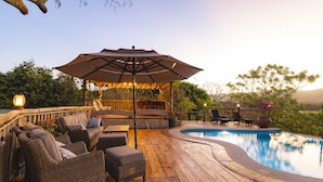 A wooden deck with outdoor furniture, a pool, and a covered seating area with string lights. - Boutique Hotel at Hacienda La Norma (Veintisiete de Abril)