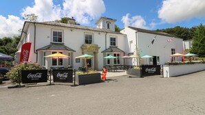 A building with outdoor seating and Coca-Cola branded signs. - Wren's Nest Manorcombe 41 (Gunnislake)