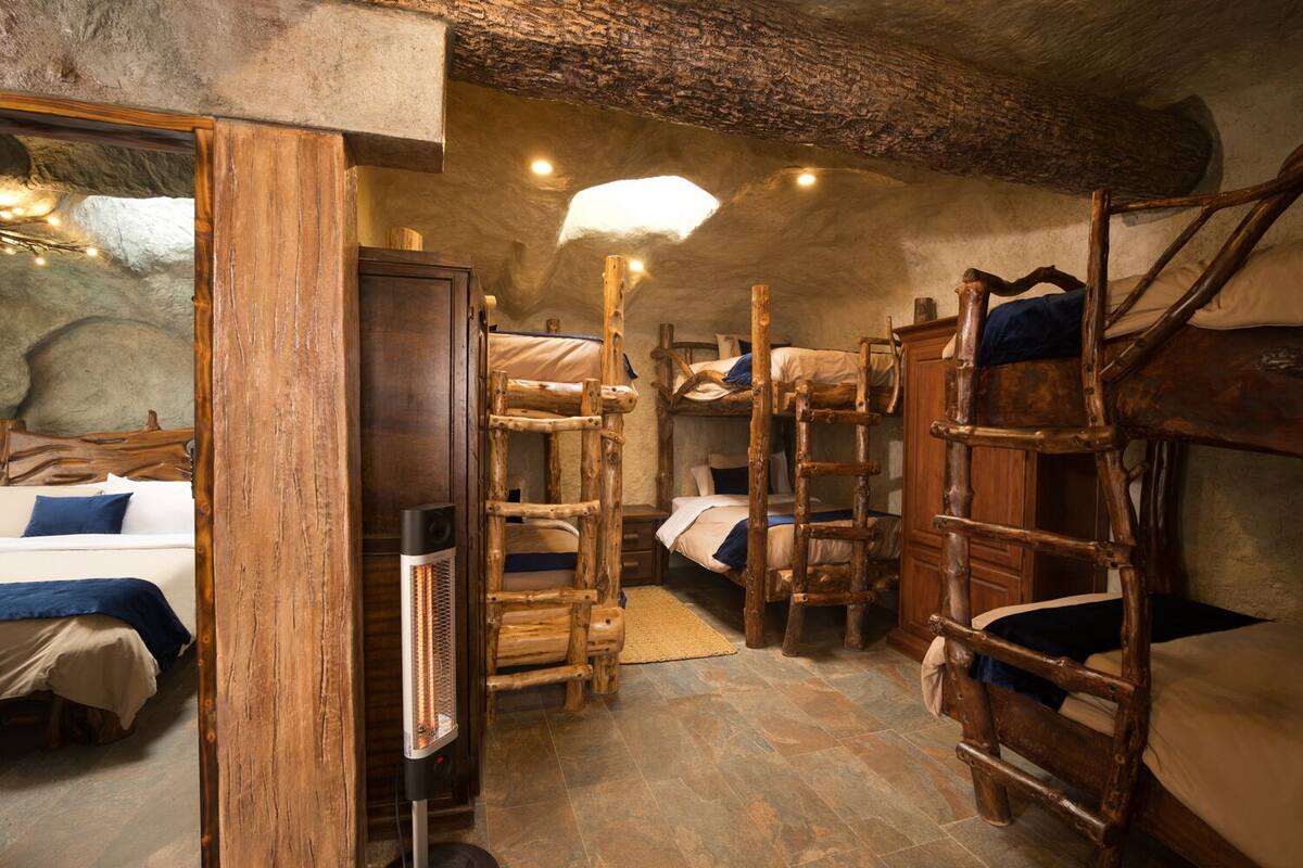 Une chambre rustique avec des lits superposés, un radiateur et un mur en pierre.