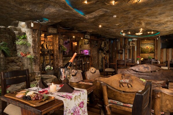 Un intérieur rustique avec des murs en pierre, des meubles en bois et une table dressée pour le repas.