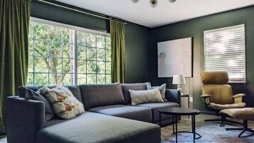 Una sala de estar con un sofá modular, una mesita, una silla y una lámpara.