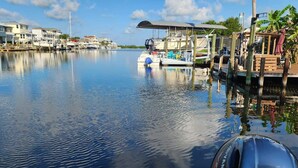 A marina with boats docked, a dock with a covered area, and houses along the waterfront. - Double Waterfront Property with Amazing Views & Private Pool (Hernando Beach)
