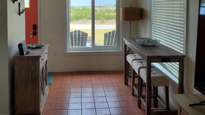 A room with a large window, a dining table with chairs, a lamp, and a TV. - Double Waterfront Property with Amazing Views & Private Pool (Hernando Beach)