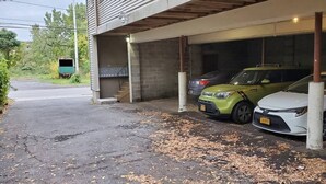 Een parkeergarage met twee auto's die onder een overdekt gebied staan.