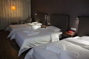 Una habitación de hotel con tres camas, un escritorio y una silla.
