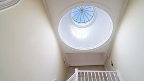 A narrow stairwell with a skylight at the top.