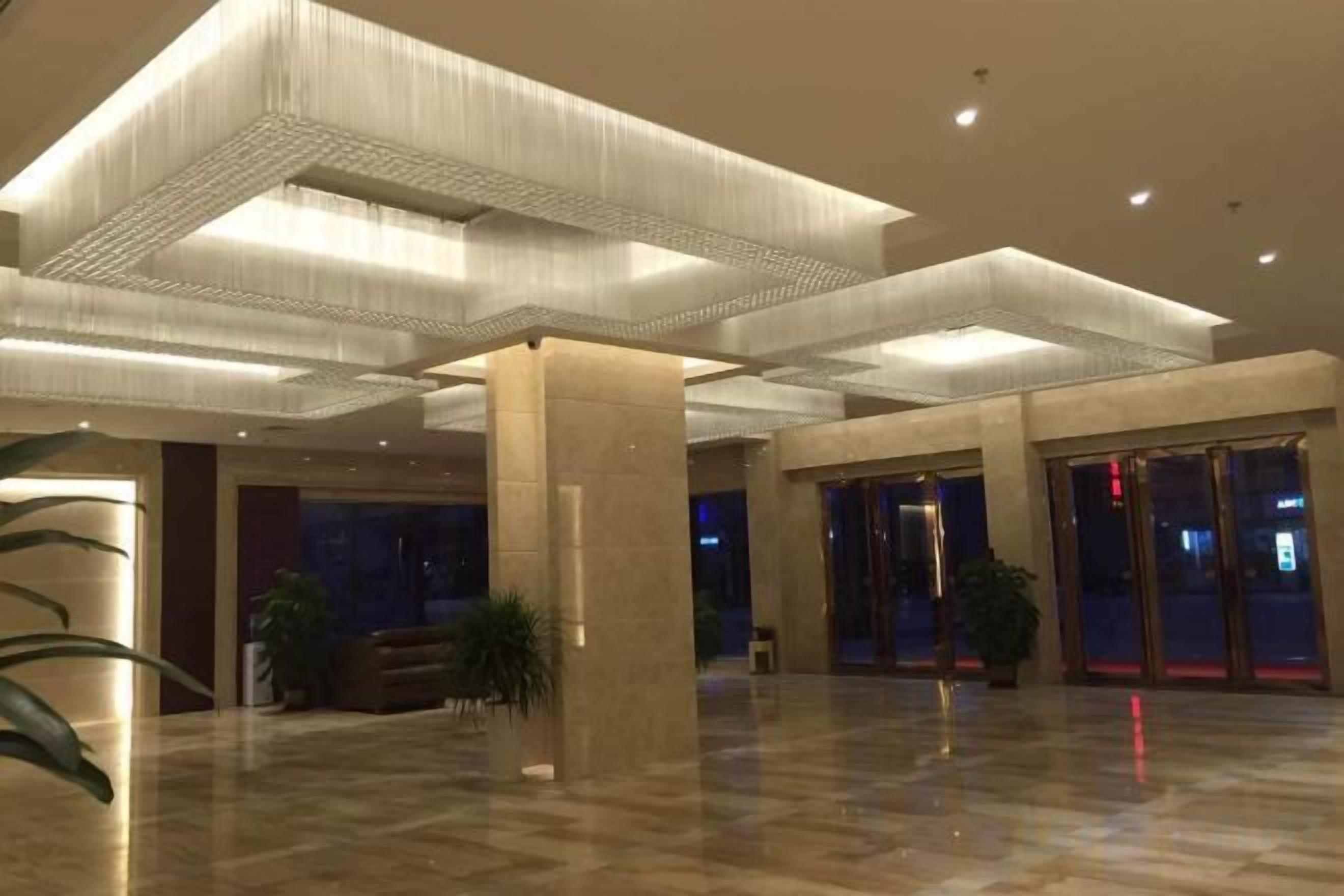A spacious lobby with a high ceiling, large pillars, and a polished floor.
