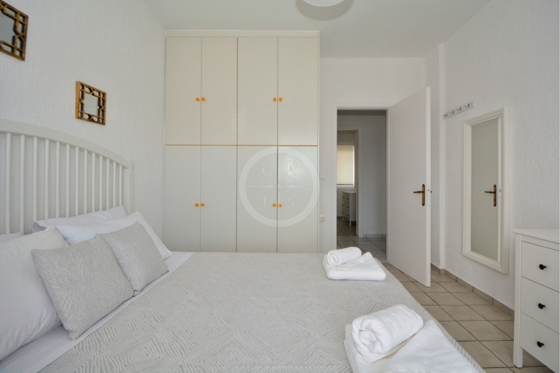 A bedroom with a bed, a wardrobe, and a bathroom visible through an open door.
