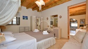 A bedroom with two beds, a dresser, a vanity, and a mirror. - Estia Stone-Built Cottage, the perfect family getaway (Argolida)