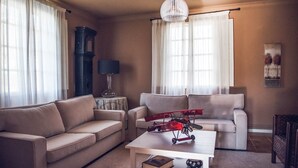 Een woonkamer met twee banken, een salontafel, een lamp en een modelvliegtuig.