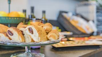 Una mesa de buffet con pasteles y un expositor de vidrio.