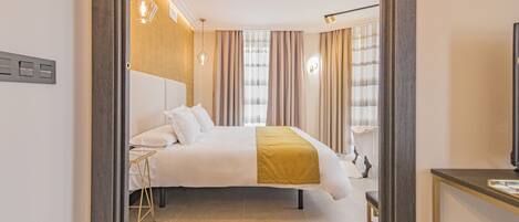 Une chambre d’hôtel moderne avec un grand lit, une table de chevet et un téléviseur.