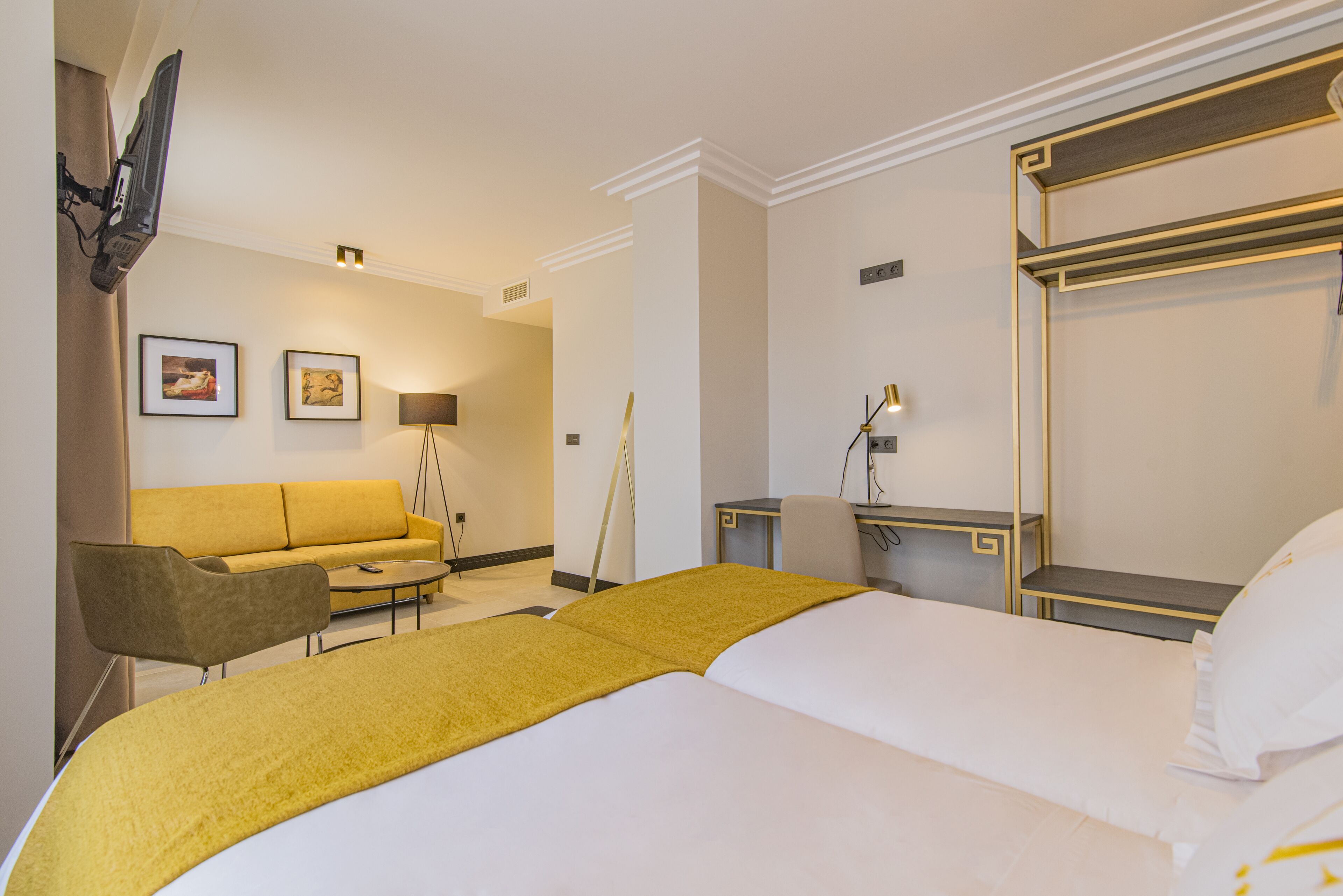 Una habitación de hotel con cama, sofá, escritorio y silla.