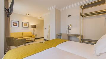 Una habitación de hotel con cama, sofá, escritorio y silla.