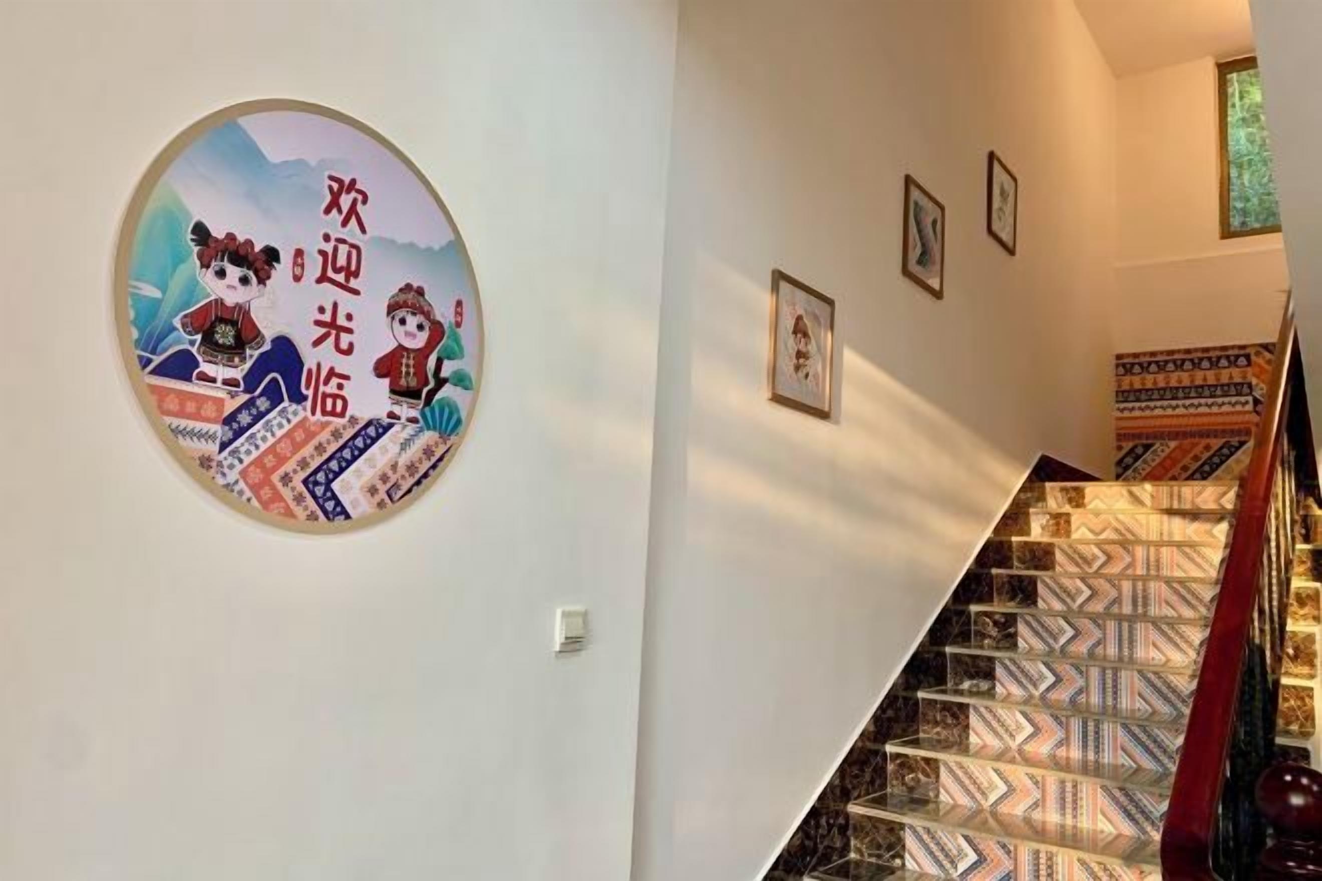 A staircase with patterned carpet and a wall with framed pictures.