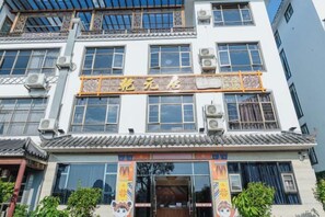 Un bâtiment présentant des éléments d’architecture chinoise traditionnelle, notamment des toits couverts de tuiles et des éléments décoratifs en treillis de bois.