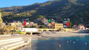 A coastal town with a marina, buildings, and a hillside backdrop. - Casa Isabella Monterosso (Monterosso al Mare)