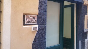 A house sign reading "Casa Isabela" and a door with a dark frame and green door handle. - Casa Isabella Monterosso (Monterosso al Mare)