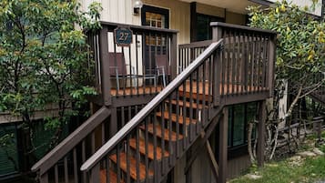 A wooden staircase leading to a porch with a sign indicating 'Villa 27.'