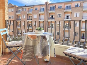 A balcony with a table, chairs, and a potted plant. - [Angels Suite] a stone's throw from Assisi (Santa Maria degli Angeli)