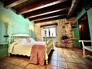 Cozy retreat with a traditional bed, wooden headboard, and comfortable chair.