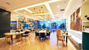 A modern interior with wooden flooring, multiple seating areas, and a view through large windows. - Magnotel (Rizhao)