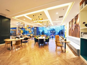 A modern interior with wooden flooring, multiple seating areas, and a view through large windows. - Magnotel (Rizhao)