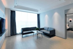 A modern living room with a sofa, coffee table, and a TV. - Magnotel (Rizhao)