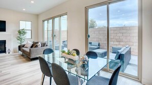 Un salon moderne avec une table à manger en verre, un canapé et une cheminée.