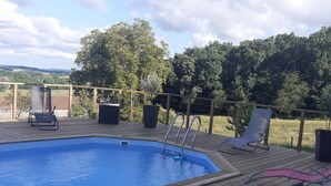 A wooden deck with a swimming pool, lounge chairs, and a view of the countryside. - House with swimming pool 2 minutes from Lougratte lake, ideal for families. (Cancon)