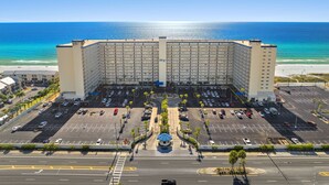 Un hotel grande con varios pisos, un estacionamiento y vista al océano.