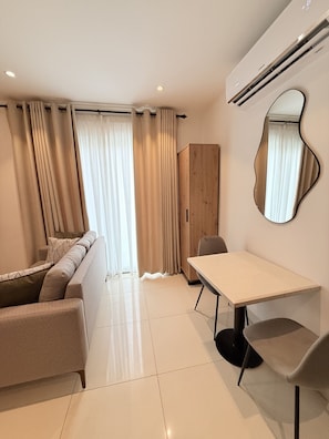 Una sala moderna con un sofá, una mesa de comedor y un espejo.