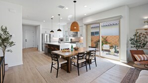 A modern kitchen with a central island, pendant lighting, and a view to a backyard. - Desert mountain views w/ pool, fire pit & hot tub (La Quinta)
