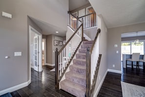 A staircase with wooden railings and carpeted steps leading to an upper floor. - 6BR Home w/ Pool - Spooky Nook/MiamiU/KingsIsland (Hamilton)