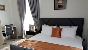A modern hotel room with a large bed, a desk, and a television. - luxurious apartment 1 bedroom ,1 bathroom with many exciting amenities  (Accra)