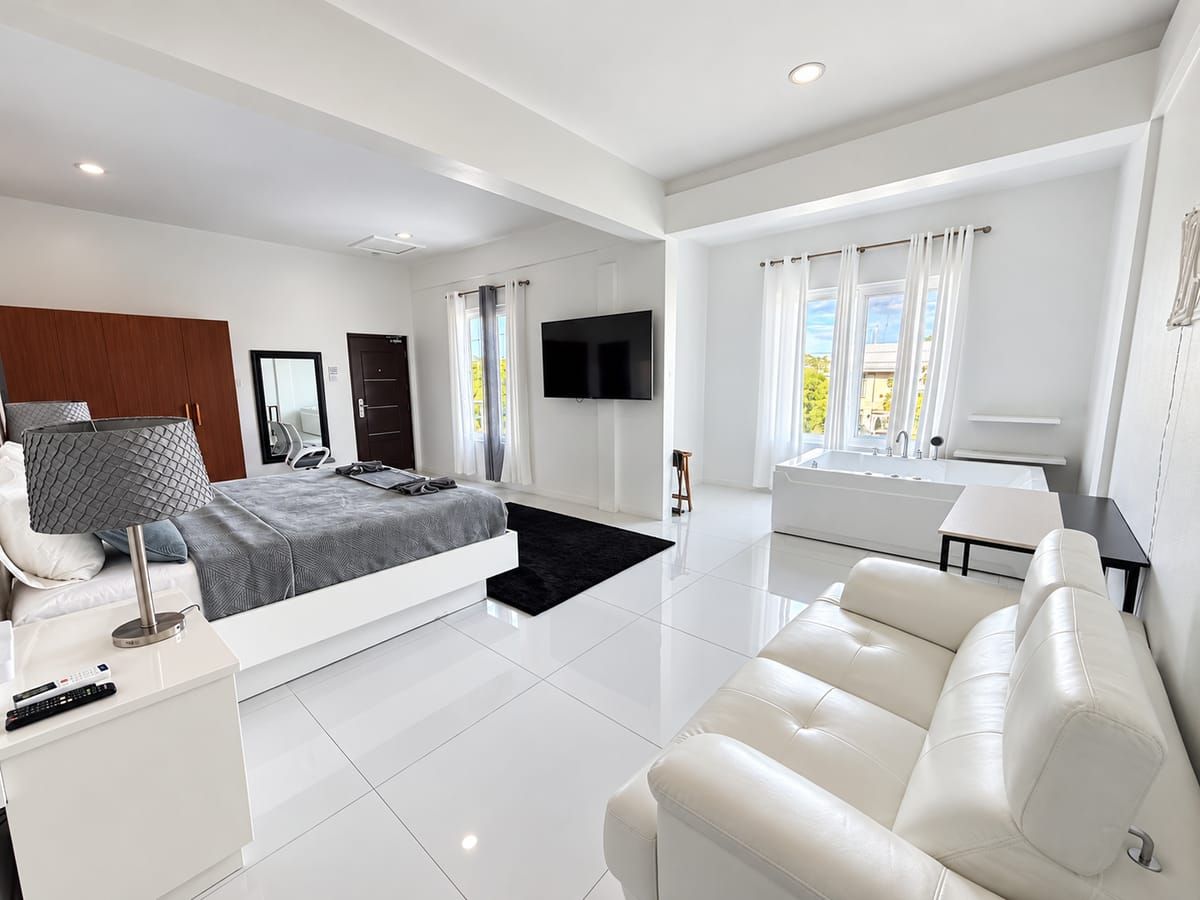 A modern bedroom with a bed, bedside table, and a TV.