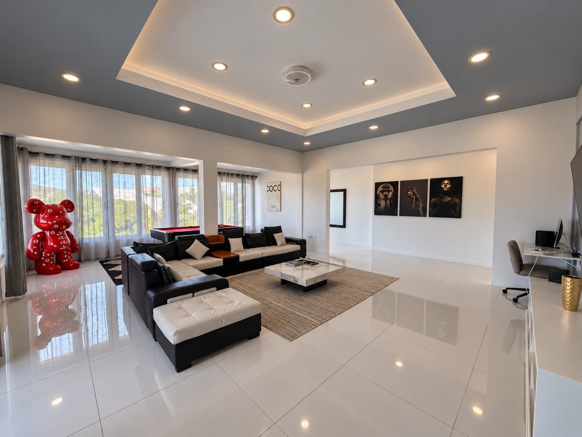 A spacious living room with a sectional sofa, a coffee table, and a red teddy bear decoration.