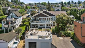 A two-story house with a rooftop deck, a garage, and a driveway. - Cozy Old Town condo + Garage + Patio Steps to Ruston Way! (Tacoma)