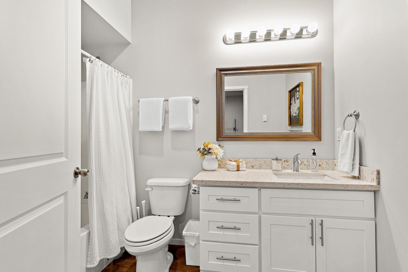 Une salle de bain équipée de toilettes, d’un lavabo, d’un meuble-lavabo et d’un miroir.