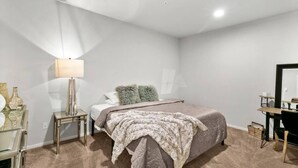 A bedroom with a bed, a nightstand, a lamp, a dresser, and a mirror. - Quiet condo Steps to Tacoma Dome~Bay & City VIEWS! (Tacoma)