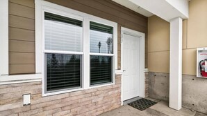 A house with a brick exterior, two white doors, and a fire extinguisher mounted on the wall. - Quiet condo Steps to Tacoma Dome~Bay & City VIEWS! (Tacoma)