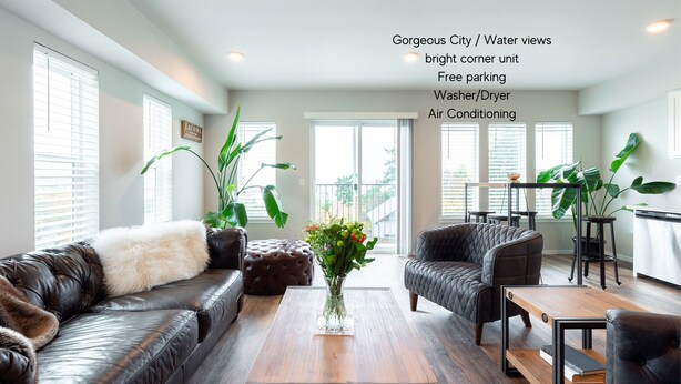 A modern living room with leather sofas, a coffee table, and potted plants. - Tacoma Dome condo w Mountn & Bay views + + PRK! (Tacoma)